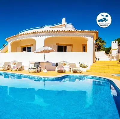 a villa with a swimming pool in front of a house at Villa Grace Bay by Algarve Vacation in Guia