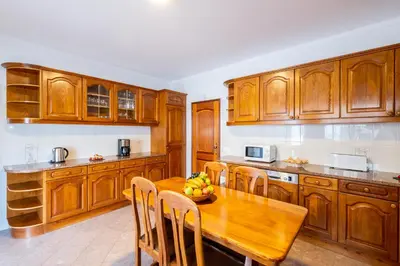 a kitchen with wooden cabinets and a wooden table at Villa Grace Bay by Algarve Vacation in Guia