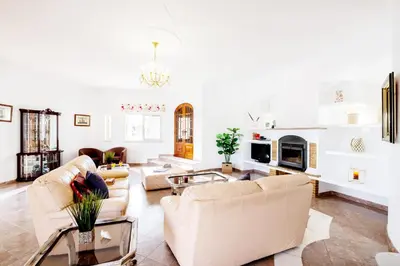 a living room with white furniture and a fireplace at Villa Grace Bay by Algarve Vacation in Guia