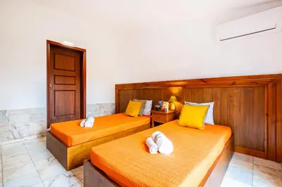 two beds in a room with yellow and white pillows at Villa Bantayan by Algarve Vacation in Albufeira