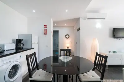 a kitchen and dining room with a table and a washing machine at Serenity by Intiholidays in Quarteira