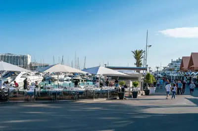 people walking around an outdoor market with tables and umbrellas at Serenity by Intiholidays in Quarteira