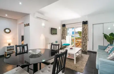a dining room and living room with a glass table at Serenity by Intiholidays in Quarteira