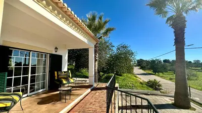 a porch with chairs and a palm tree on a house at Abby by Check-in Portugal in Albufeira
