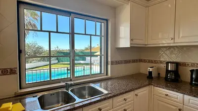 a kitchen with a sink and a large window at Abby by Check-in Portugal in Albufeira