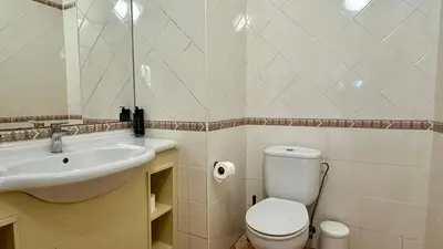a bathroom with a white toilet and a sink at Abby by Check-in Portugal in Albufeira