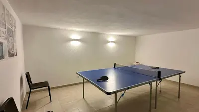 a ping pong table in a room with a chair at Abby by Check-in Portugal in Albufeira