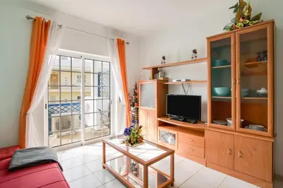 a living room with a red couch and a tv at Bosque São José Af in Albufeira