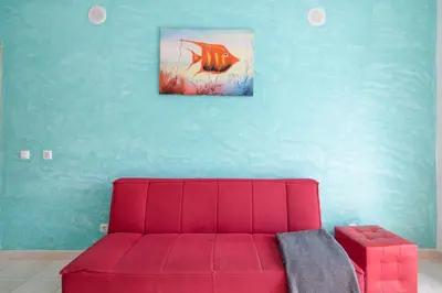 a red couch in a room with a blue wall at Bosque São José Af in Albufeira