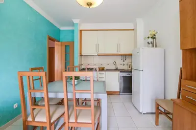 a kitchen with a table and chairs and a refrigerator at Bosque São José Ag in Olhos de Água