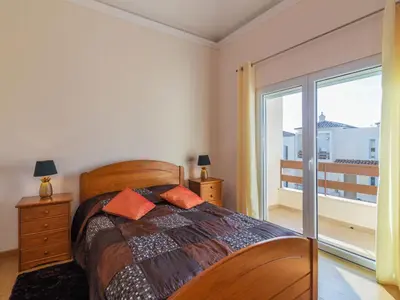 a bedroom with a bed and a sliding glass door at Holiday Home Bela Vitta by Interhome in Ferreiras