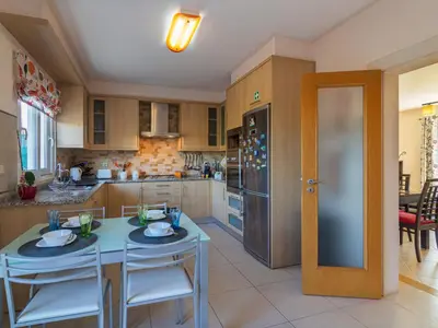 a kitchen with a table and chairs and a refrigerator at Holiday Home Bela Vitta by Interhome in Ferreiras
