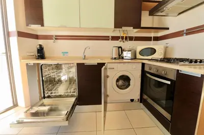 a kitchen with a washing machine and a dishwasher at Olhos De Água 1BR with Pool, AC and Free Parking in Albufeira