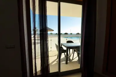 a balcony with a table and a view of the ocean at Olhos De Água 1BR with Pool, AC and Free Parking in Albufeira