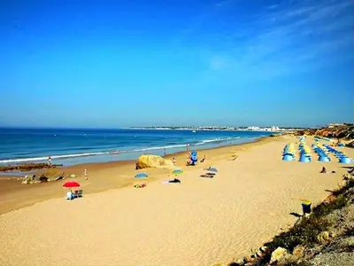 a beach with many umbrellas and people on the sand at Stunning Luxury Villa Private Pool, Galé Albufeira in Albufeira
