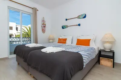 two beds in a bedroom with a window at Blue Apartment Balaia Space - By Dalma Portuguesa in Albufeira