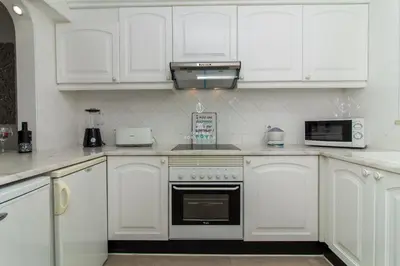 a kitchen with white cabinets and a stove top oven at Blue Apartment Balaia Space - By Dalma Portuguesa in Albufeira
