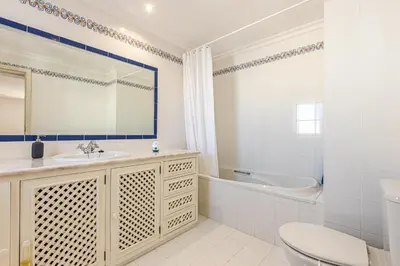a bathroom with a sink and a tub and a toilet at Villa Cecília in Albufeira