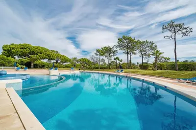 a large swimming pool with blue water at Apartment Victoria - Quinta do Lago in Quinta do Lago
