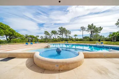 a swimming pool with a fountain in a park at Apartment Victoria - Quinta do Lago in Quinta do Lago