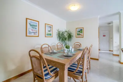 a dining room with a wooden table and chairs at Apartamento no Clube Praia da Oura in Albufeira