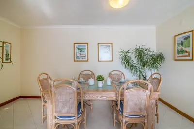a dining room with a wooden table and chairs at Apartamento no Clube Praia da Oura in Albufeira