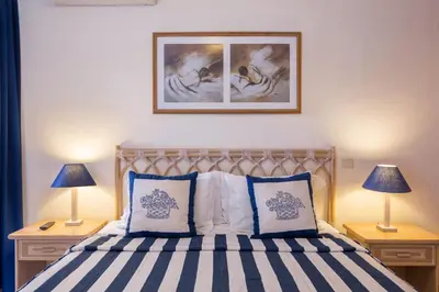 a bedroom with a bed with two lamps and a picture on the wall at Apartamento no Clube Praia da Oura in Albufeira