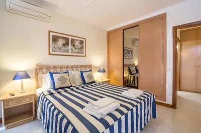 a bedroom with a bed with blue and white sheets at Apartamento no Clube Praia da Oura in Albufeira