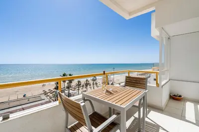 a balcony with a table and chairs and the beach at Praia Mar in Quarteira