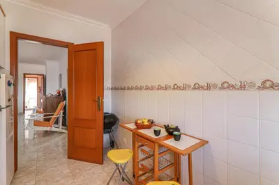 a kitchen with a table and some stools in a room at Casa do Algarve in Albufeira