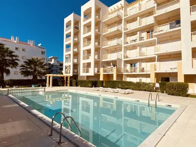 a swimming pool in front of a large apartment building at Vista by Check-in Portugal in Albufeira