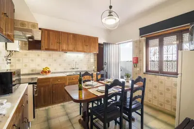 a kitchen with a wooden table and chairs in it at Casa Guerreiro in Branqueira