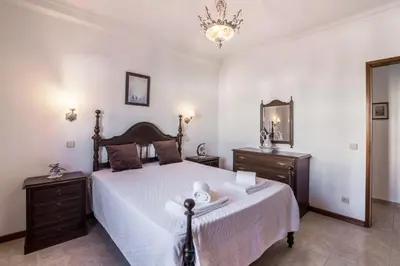 a bedroom with a large white bed with two night stands at Casa Guerreiro in Branqueira