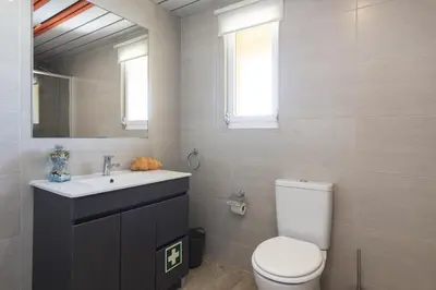 a bathroom with a toilet and a sink and a mirror at Marina Pearl - View to Vilamoura Marina in Vilamoura