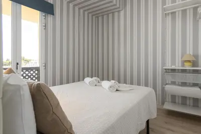 a white bedroom with a bed with towels on it at Marina Pearl - View to Vilamoura Marina in Vilamoura