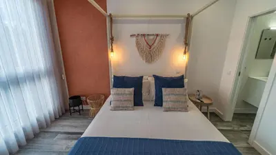 a bedroom with a large bed with blue pillows at Plan Be GuestHouse in Faro