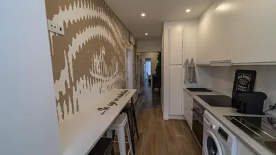 a kitchen with white cabinets and a counter top at Plan Be GuestHouse in Faro