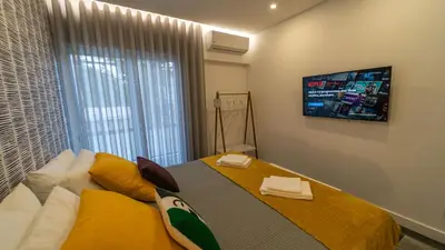 a bedroom with a bed with a tv on the wall at Plan Be GuestHouse in Faro