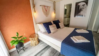 a small bedroom with a bed with blue sheets and pillows at Plan Be GuestHouse in Faro