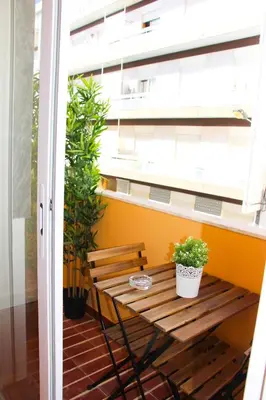 a wooden bench on a balcony with a window at Apartamentos SweetHomes in Faro
