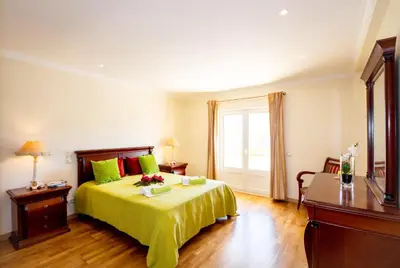 a bedroom with a bed with green sheets and a window at Villa Samoa by Algarve Vacation in Albufeira