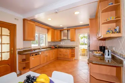 a kitchen with wooden cabinets and a counter top at Villa Samoa by Algarve Vacation in Albufeira