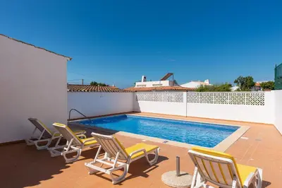 a patio with chairs and a swimming pool at Oura Family House in Albufeira