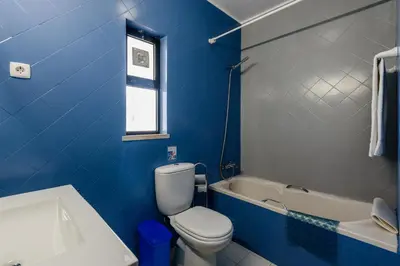 a blue bathroom with a toilet and a bath tub at Villa Protea - 5 bedroom, beach, air-con, wifi in Albufeira