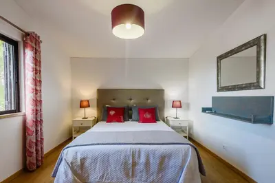 a bedroom with a large bed with red pillows at Villa Protea - 5 bedroom, beach, air-con, wifi in Albufeira