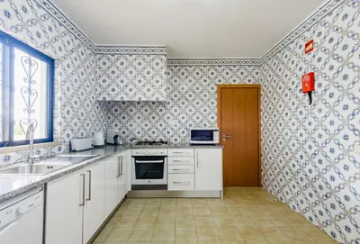 a kitchen with white cabinets and blue and white wallpaper at Villa Protea - 5 bedroom, beach, air-con, wifi in Albufeira