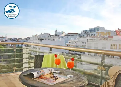 a table with two glasses on a balcony with a view at Apartment Orlando by Algarve Vacation in Albufeira