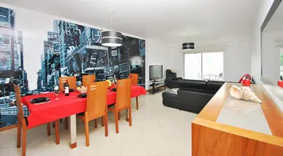 a living room with a red table and a couch at Apartment Orlando by Algarve Vacation in Albufeira