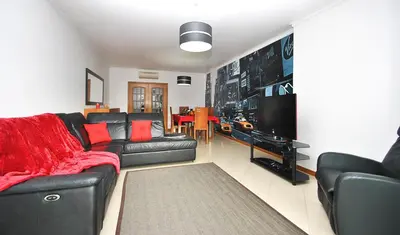 a living room with a black couch and a television at Apartment Orlando by Algarve Vacation in Albufeira