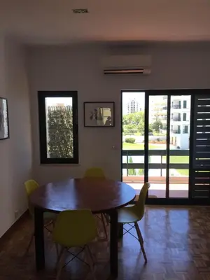 a dining room with a wooden table and chairs at Tossan House in Vilamoura Downtown in Quarteira